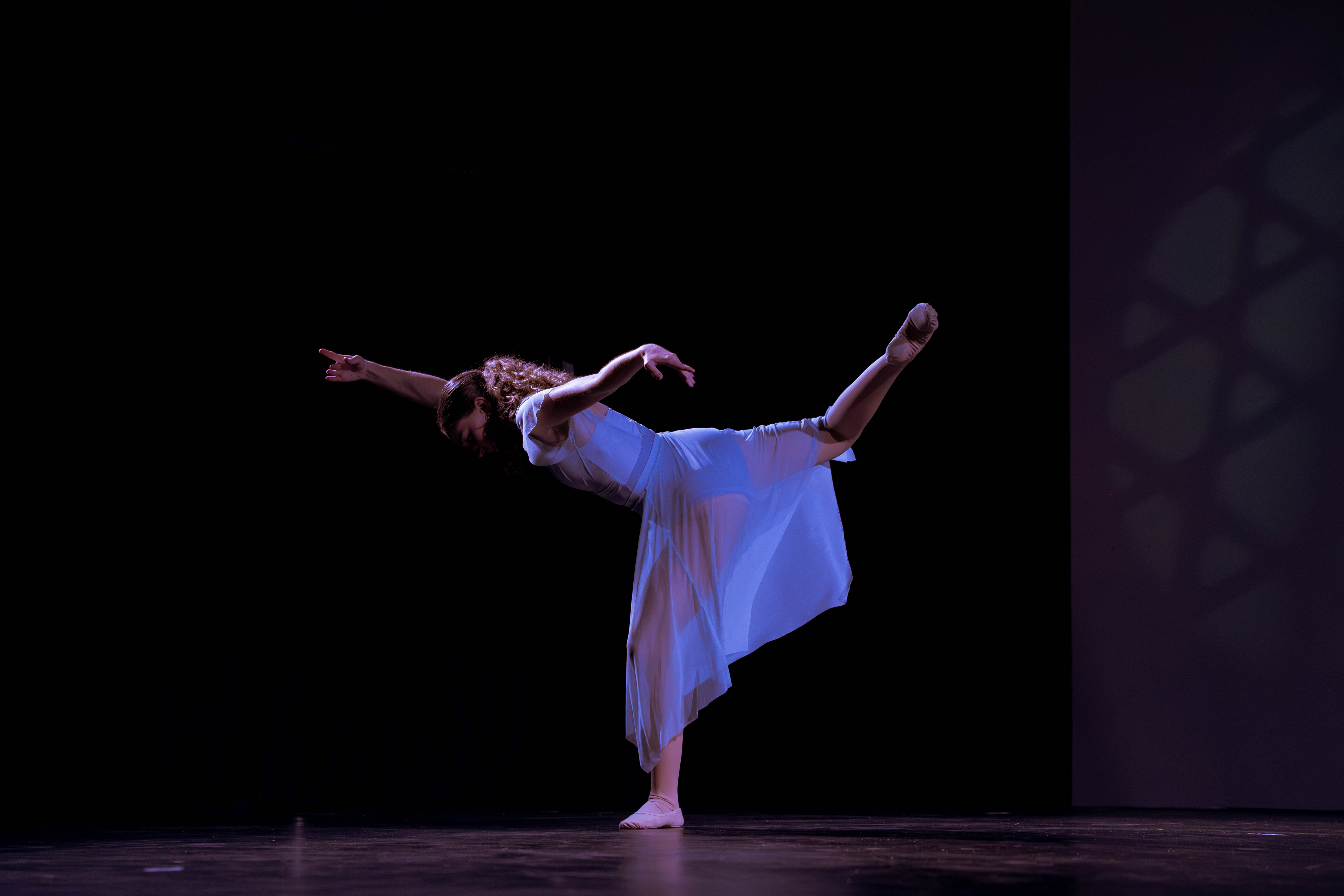 VelaDance dancer in a flowing white dress holding an arabesque — South Jersey contemporary dance company