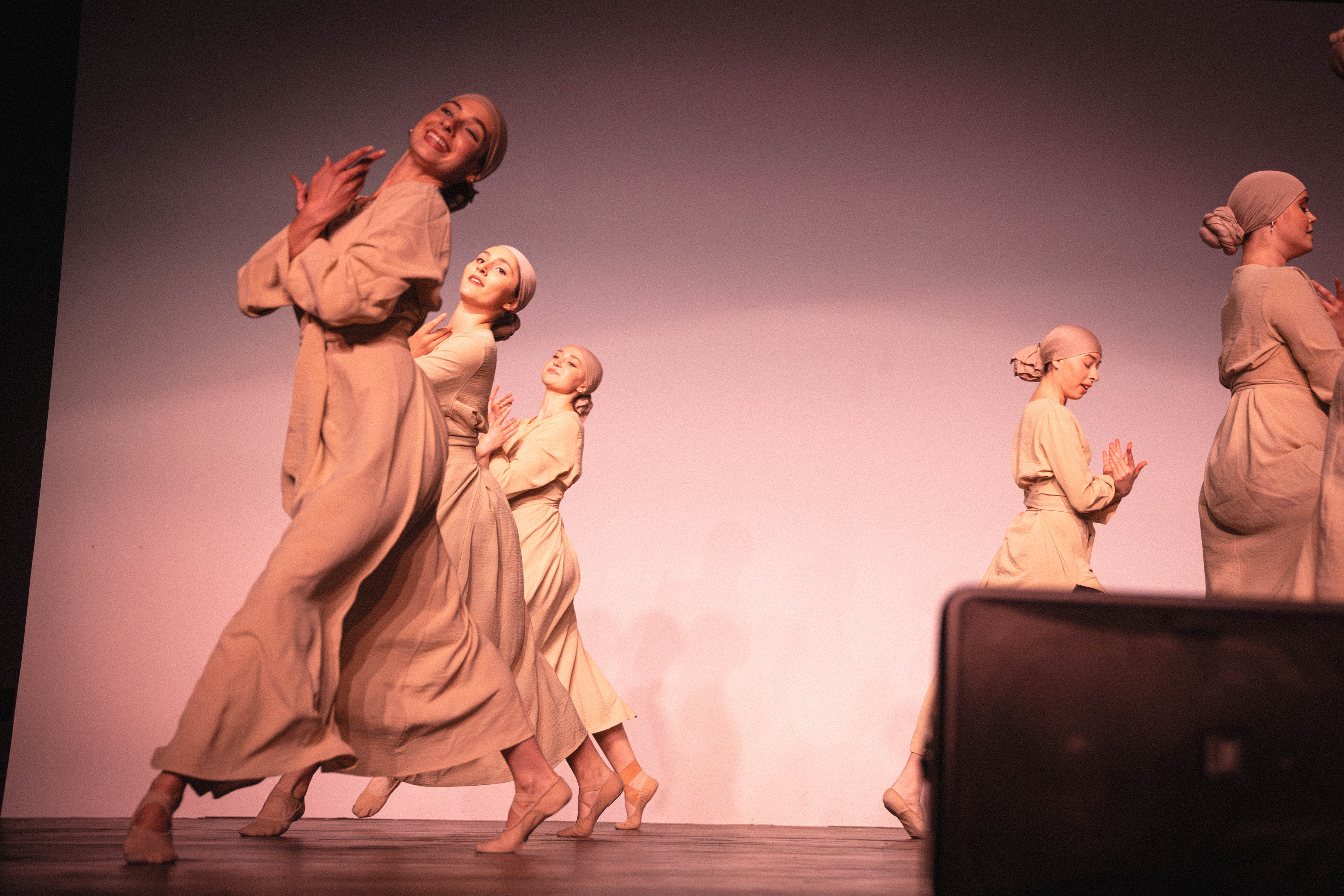VelaDance ensemble in a sculptural group tableau under warm light — professional dance company New Jersey