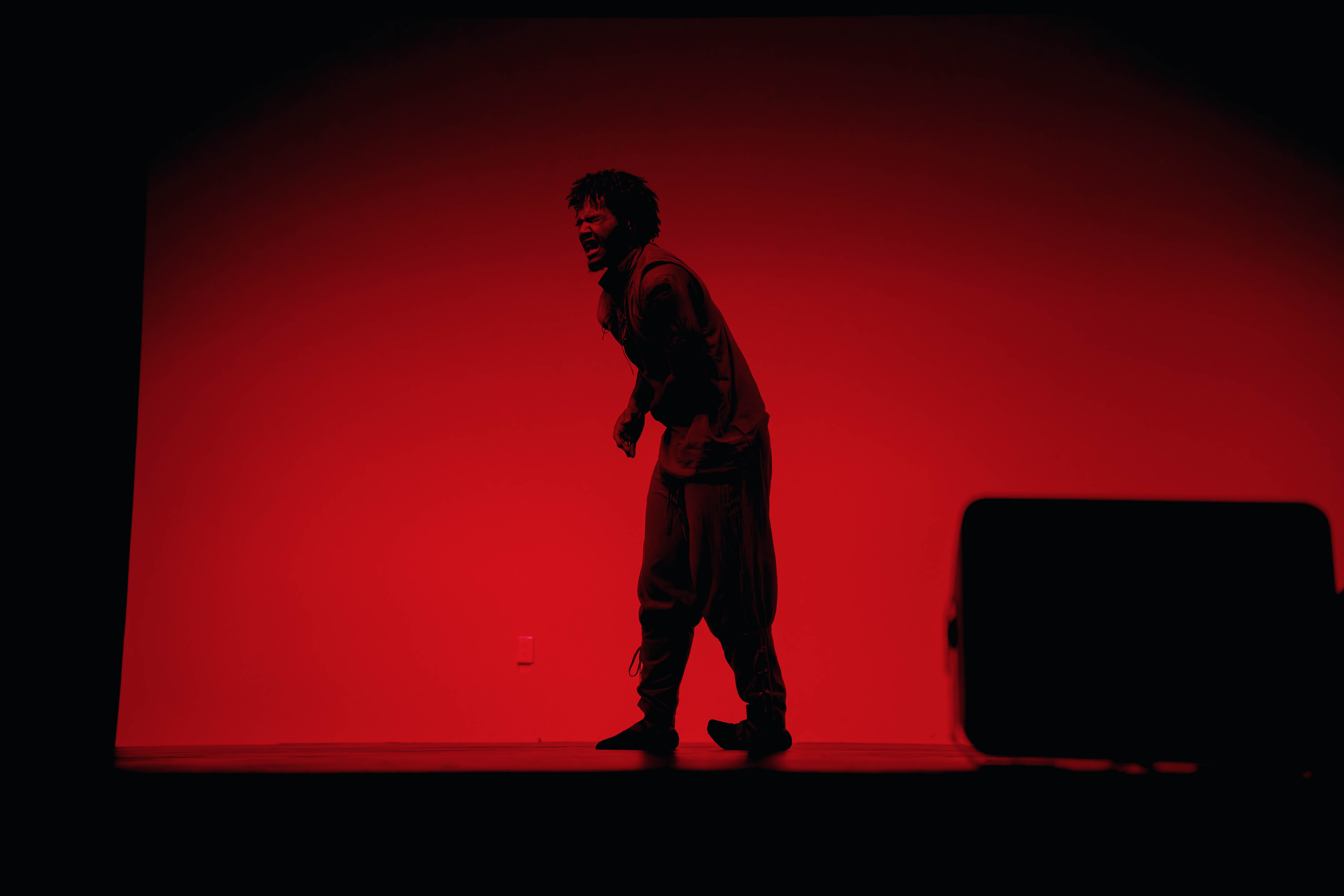 VelaDance dancer expressing raw emotion in red stage light — South Jersey modern dance company